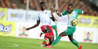 Harambee Stars defender Joseph Okumu (left) vies with Comoros forward Ahmed Mogni