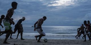 People play football at the Beau Fallon beach in Mahe island in Seychelles.