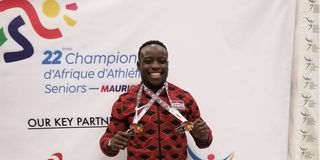 Ferdinand Omanyala poses with his gold medal