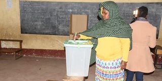 A voter casting her ballot at Mercy Njeri Primary School