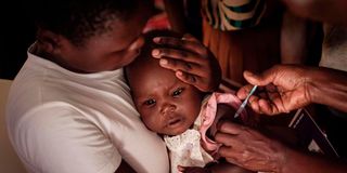 A child receives a shot during the launch of the extension of the world’s first malaria vaccine
