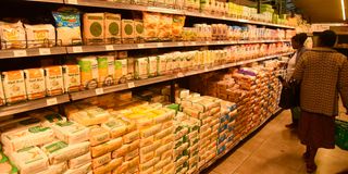 Customers countercheck the prices of maize flour at Clean-shelf Supermarket in Nakuru City