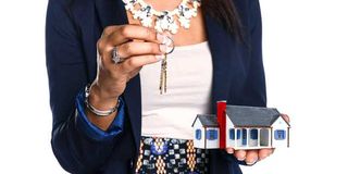 Female real estate agent holding house and keys