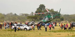 WRC fans scamper for safety as a chopper takes off from Soy Sambu spectator area