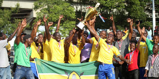 National Cereals and Produce Board players and officials celebrate with the trophy